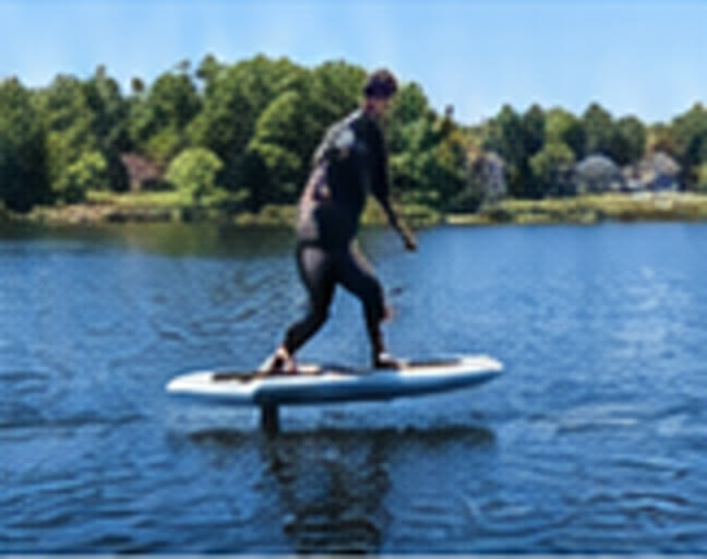 Rider standing on the eFoil board and riding across the water